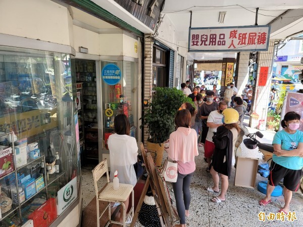 國內疫情持續升溫，家用快篩試劑需求量大增，藥局前民眾排長龍準備購買。（記者佟振國攝）